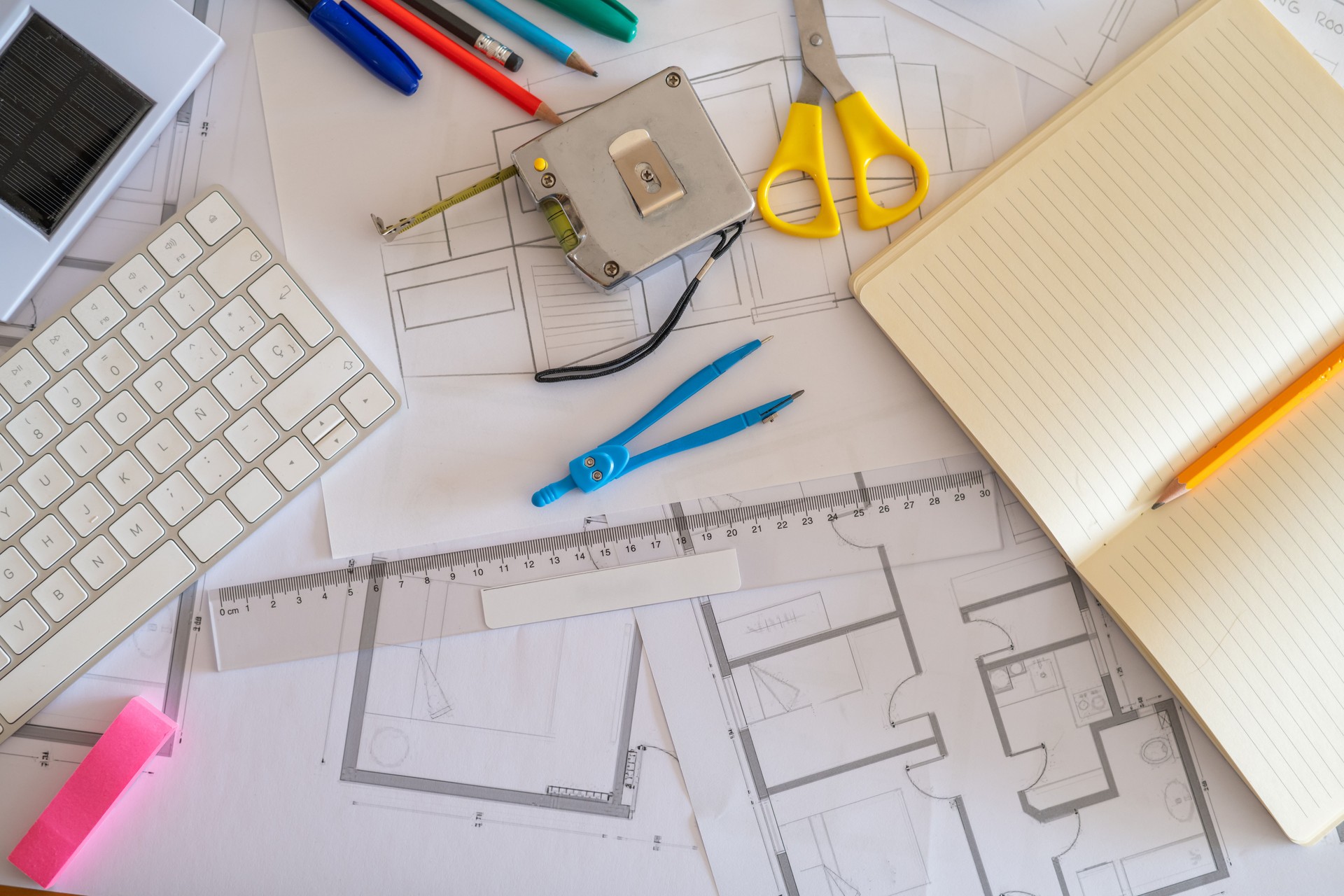 Workspace of an architect designing a sustainable building with solar panels, surrounded by blueprints, eco-friendly materials, and various drafting tools